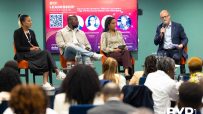 Panelists at the BYP Leadership Conference 26 discussing inclusion and high performance, with a speaker at the podium.
