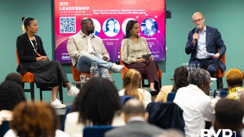 Panelists at the BYP Leadership Conference 26 discussing inclusion and high performance, with a speaker at the podium.