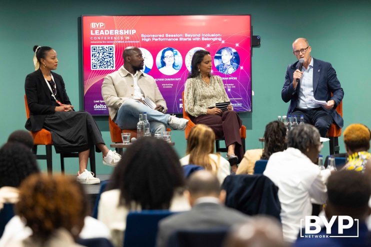 Panelists at the BYP Leadership Conference 26 discussing inclusion and high performance, with a speaker at the podium.