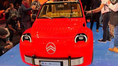 Red Citroen CV2 concept car on display at the Paris Motor Show, surrounded by attendees.