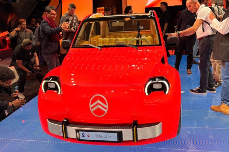 Red Citroen CV2 concept car on display at the Paris Motor Show, surrounded by attendees.