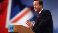 David Cameron speaking at a podium, Union Jack flag backdrop, Leadership for a Better Future visible.
