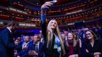 Young woman taking a selfie at the Conservative Party Conference 2026, with delegates in the background.