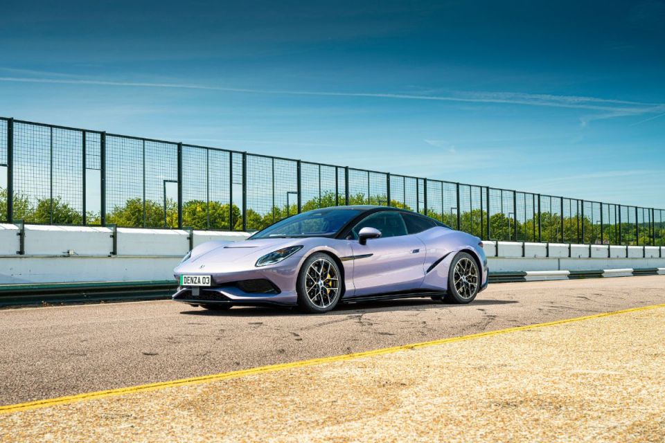 Sleek purple Denza 03 sports car on a race track under a clear blue sky, showcasing its design and performance.