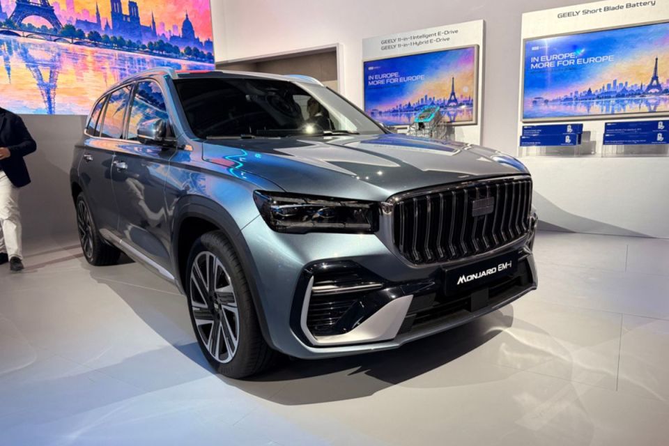 Geely Monjaro EM-I SUV in light blue, displayed on a showroom floor with MORE FOR EUROPE signage.