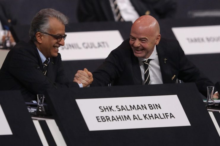 Gianni Infantino shaking hands with Sheikh Salman bin Ebrahim Al Khalifa at a formal event, both smiling.