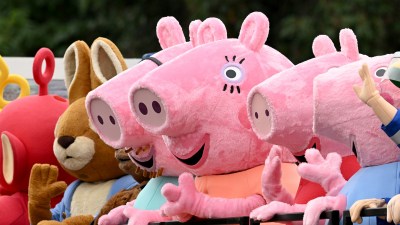 Peppa Pig and other childrens cartoon character mascots in a parade or event