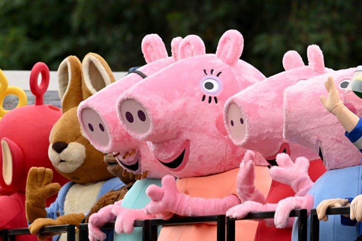 Peppa Pig and other childrens cartoon character mascots in a parade or event