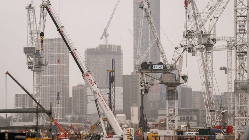 HS2 construction site with multiple cranes, buildings under development, and Select plant hire equipment on a cloudy day