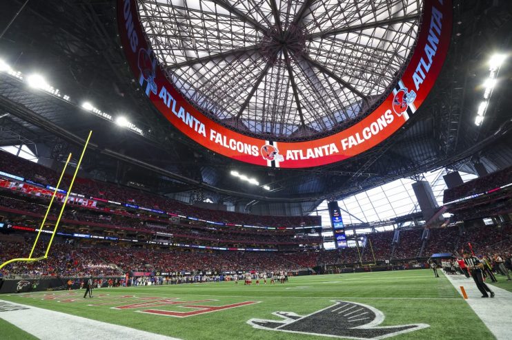 Interior view of Mercedes-Benz Stadium with the Atlanta Falcons logo and text on the upper ring display.