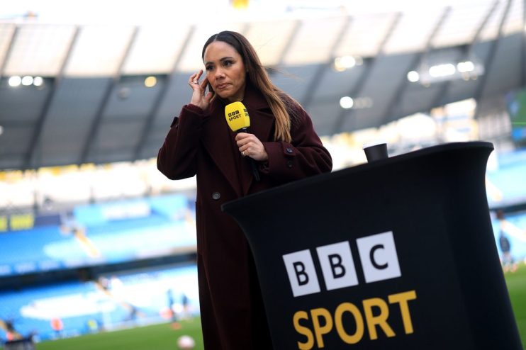 Alex Scott, former England footballer and BBC Sport pundit, reporting from a stadium pitchside with a BBC microphone.
