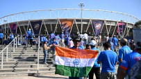 Cricket fans with an Indian flag entering a stadium, ICC T20 World Cup banners visible in the background