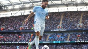 Manchester City player in light blue kit with soccer ball on field during game