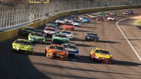 NASCAR stock cars racing on an oval track, with a yellow Pennzoil sign visible above the track.