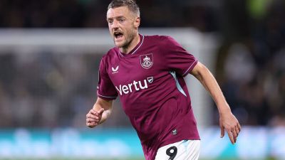 Jamie Vardy in a burgundy Leicester City football kit with Vertu sponsor, number 9, on a pitch