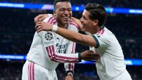 Kylian Mbapp&eacute; in a white jersey with number 10, celebrating with a teammate on a soccer field.