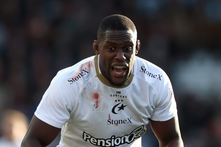 Maro Itoje, Saracens rugby player, shouts on the field with blood stains on his white jersey.