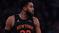 Basketball player in a New York Knicks jersey with 32 and NEW YORK visible, looking right.