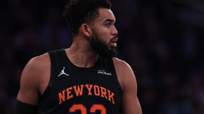 Basketball player in a New York Knicks jersey with 32 and NEW YORK visible, looking right.
