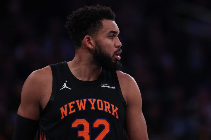 Basketball player in a New York Knicks jersey with 32 and NEW YORK visible, looking right.