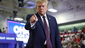 Donald Trump points at a political rally with an OHIO VOTE ON sign in the background.