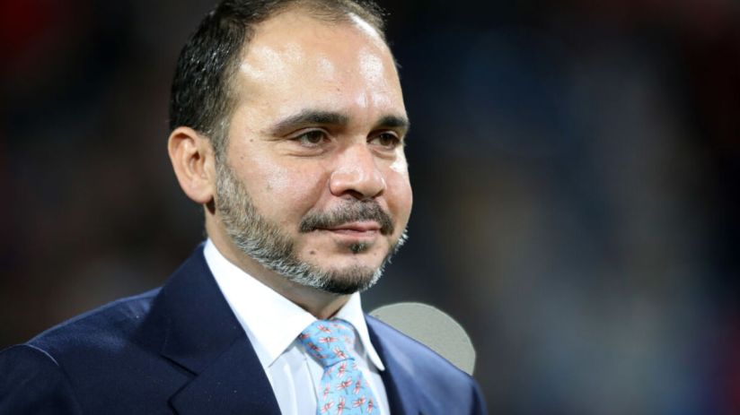 Prince Ali bin Hussein of Jordan, wearing a blue suit and patterned tie, looking right.