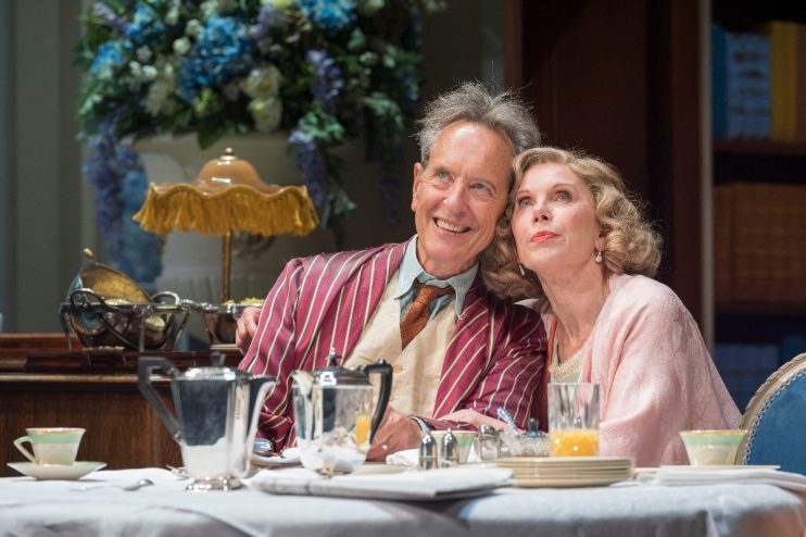 Richard E. Grant and Christine Baranski in Hay Fever, West End play, seated at a breakfast table.