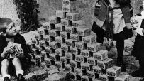 Children playing with stacks of German Mark banknotes during hyperinflation in 1920s Germany, illustrating economic crisis.