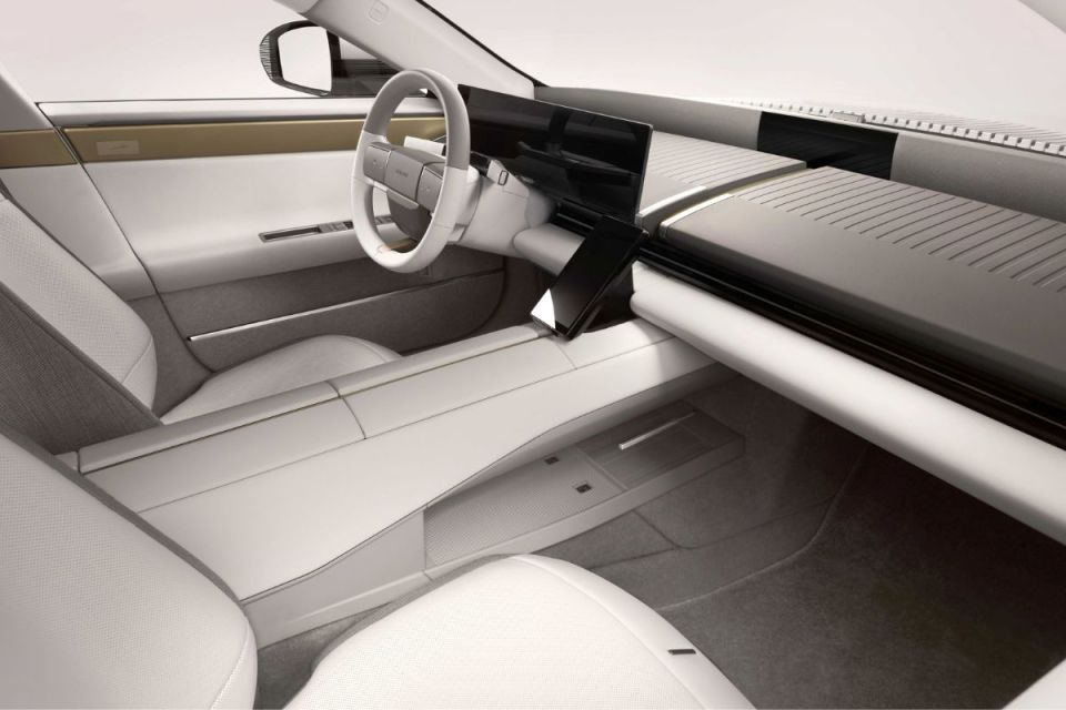 Sleek, modern Jaguar car interior with light grey and white upholstery, digital displays, and minimalist dashboard design.