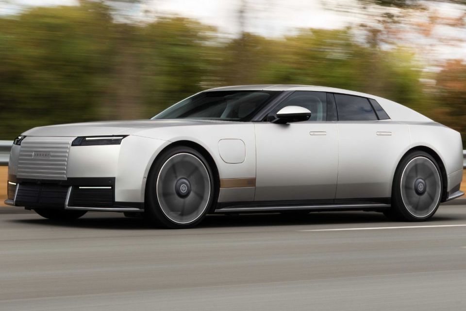 Sleek silver Jaguar electric car driving on a highway, showcasing modern design and motion blur.