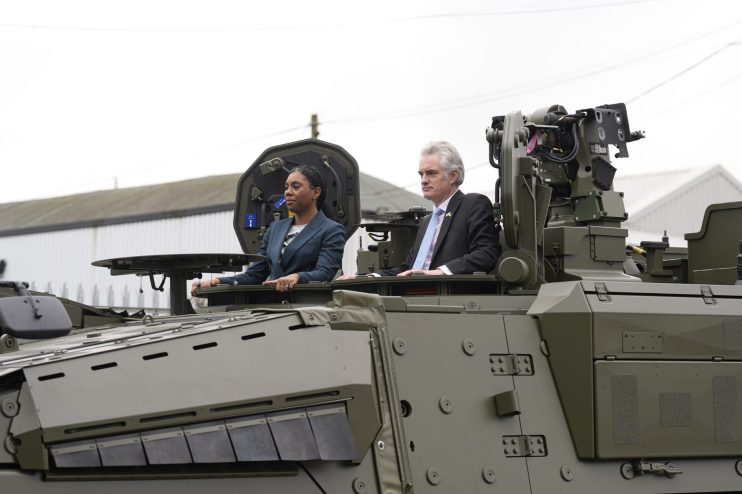 Kemi Badenoch and James Cartlidge in military vehicle, defense event