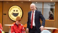 John Healey, MP, speaking with workers in orange overalls at a gas terminal.