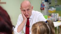 John Healey, MP, at a table with a woman and child, looking concerned about inflation