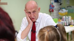 John Healey, MP, at a table with a woman and child, looking concerned about inflation