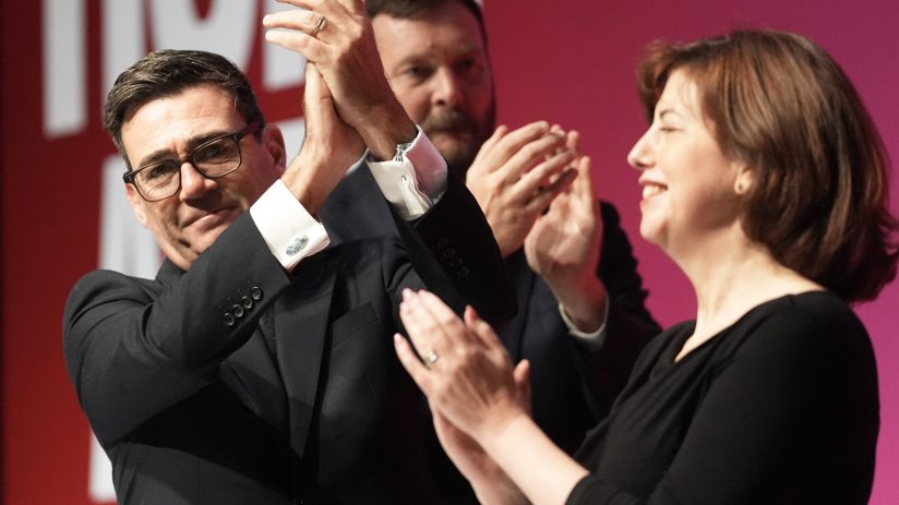 Andy Burnham, a man, and a woman clapping at the Labour Party conference