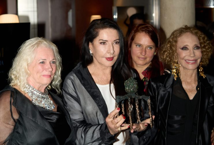 Marina Abramović holding a bronze award, flanked by three women at a Liberatum event