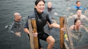 Lisa Nandy in a wetsuit climbing out of the water at Labour Party Conference 2026, smiling with other swimmers.