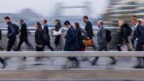 Blurred commuters walking across London Bridge during peak hour, symbolizing busy urban life