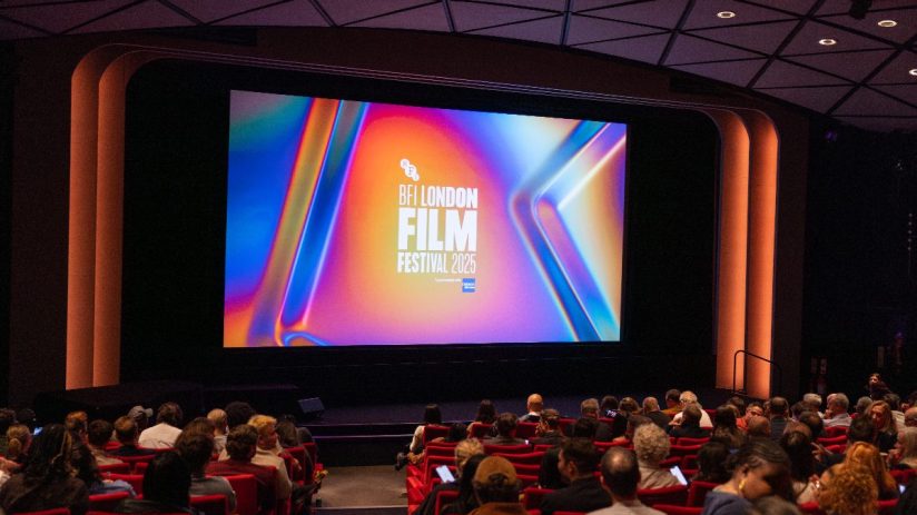Audience seated in a dark theater watching the BFI London Film Festival 2026 logo on a large screen
