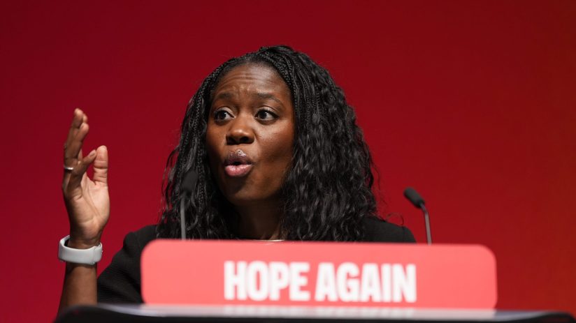 Miatta Fahnbulleh speaking at a podium with HOPE AGAIN visible, gesturing with her right hand.