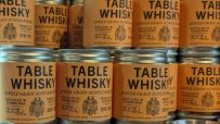Rows of Table Whisky single grain Scotch jars with orange labels, distilled in Edinburgh.