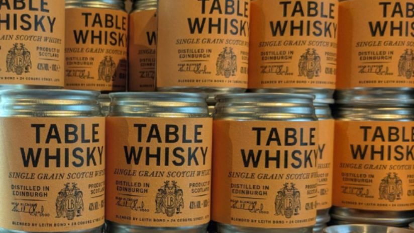 Rows of Table Whisky single grain Scotch jars with orange labels, distilled in Edinburgh.