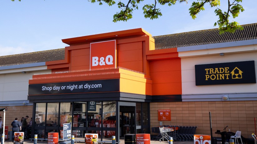 Exterior view of a B&Q store entrance with Shop day or night at diy.com and Trade Point signage.