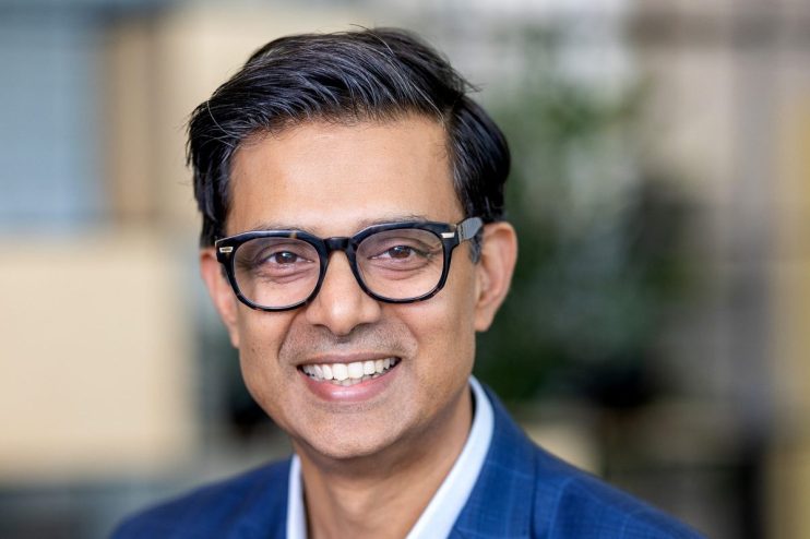 Suresh Balaji, a smiling man in glasses and a blue plaid suit jacket, looking at the camera.