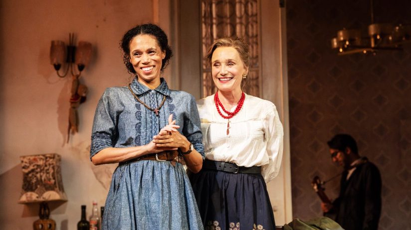 Smiling actresses from The Cherry Orchard at Harold Pinter Theatre, one in denim, one in white blouse and red beads.