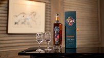 The Lakes Chocolatier limited edition whisky bottle, two branded glasses, and gift box on a dark surface