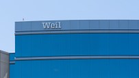 Weil Gotshal & Manges law firm building with blue reflective windows and the Weil logo on top.