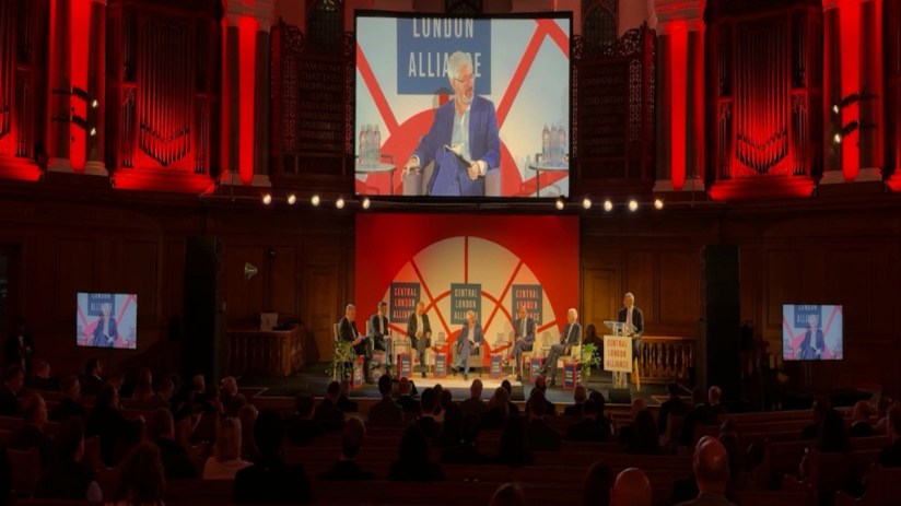 Panel discussion at the Central London Alliance Summit 2025 with speakers on stage and a large screen displaying the event...