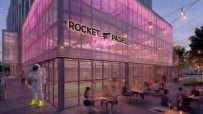 Rocket Padel Croydon exterior at dusk with pink lighting, outdoor dining, and an astronaut statue.