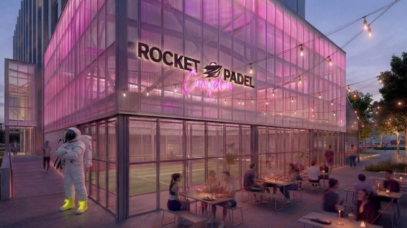Rocket Padel Croydon exterior at dusk with pink lighting, outdoor dining, and an astronaut statue.